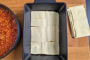 Lasagneplatten auf die Linsenbolognese schichten