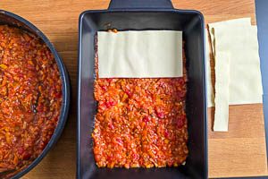 Lasagneplatten und Rote-Linsen-So&szlig;e abwechselnd in die Auflaufform schichten