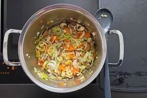 Lauch und Champignons hinzufügen und auch anbraten