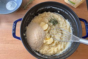 Polenta auflockern und Butter, Olivenöl und Parmesan unterrühren