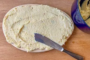 F&uuml;r Polenta-Schnitten die warme Polenta auf ein Holzbrett streichen