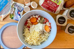 Gemüse, Magerquark, Eier, Mozzarella, Oregano, Thymian, Salz und Pfeffer in eine Schüssel geben, mit einem Deckel verschließen und gut schütteln