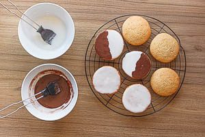 Gebäckstücke mit Zuckerguss und Schokoladenglasur bestreichen