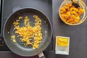 Zwiebeln, Knoblauch und Peperoni andünsten.