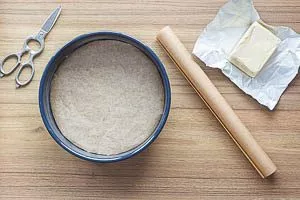 Lege den Boden der Form mit Backpapier aus und fette den Rand ein