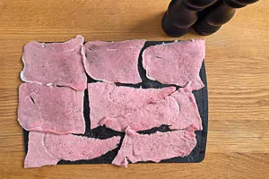 Kalbsschnitzel plattieren und mit Salz und Pfeffer w&uuml;rzen