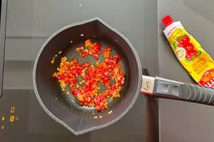 Tomatenmark zu den Zwiebeln und dem Knoblauch geben