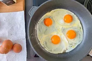 Vier Eier in die Pfanne schlagen und auf mittlere Hitze reduzieren