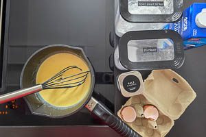 Milch, Speisestärke, Zucker, Salz, Eigelbe, ausgekratzte Vanilleschote und das Mark in einen Topf geben und unter ständigem Rühren aufkochen