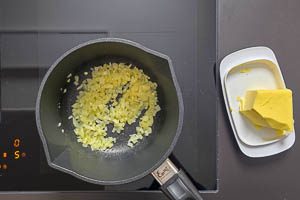Butter in einem Topf schmelzen und Zwiebelwürfel glasig dünsten