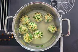 Kn&ouml;del in einem hohen Topf in Wasser kochen