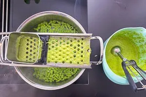 Teig f&uuml;r die B&auml;rlauchsp&auml;tzle in einen Kochtopf mit Salzwasser hobeln