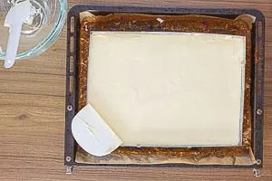 Buttercreme auf dem Kuchen im Backrahmen verstreichen