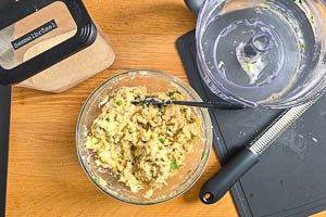 Paniermehl, Zitronenzeste, Zwiebeln und Knoblauch hinzugeben und unterr&uuml;hren