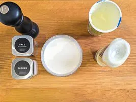 Mayonnaise, Joghurt, Salz, Pfeffer und Zucker mit dem Gurkenwasser als Dressing verr&uuml;hren
