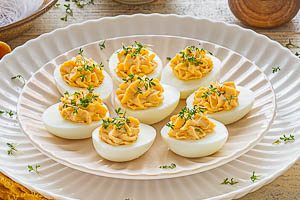 Gef&uuml;llte Eier mit frischer Kresse garnieren und servieren