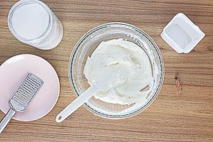 Mit dem Handrührgerät Quark, Rumaroma, Zucker und Zitronenschale vermengen