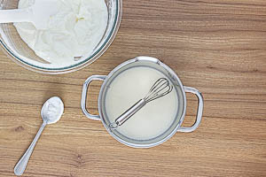 2 Esslöffel Quarkmasse zu der Zitronen-Gelatine-Mischung geben