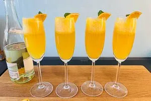 Mit Schaumwein aufgie&szlig;en und mit Minze und Orange dekorieren.