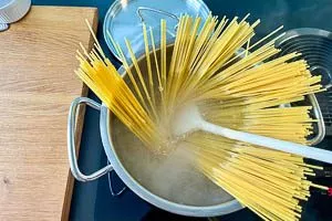 Nudeln in das kochende Salzwasser geben