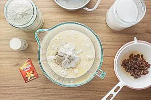 Mehl, Salz, Vanillezucker, Zucker und das Milch-Butter-Hefe-Gemisch verr&uuml;hren, dann Rosinen &uuml;ber einem Sieb abgie&szlig;en und trocknen