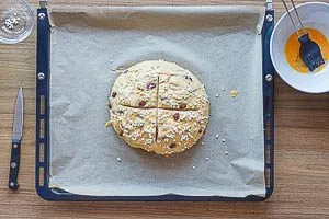 Osterbrot mit Ei bestreichen und Hagelzucker bestreuen, Kreuz einschneiden und 40 Minuten backen