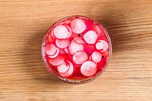 Heißen Sud über die Radieschen geben