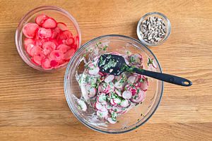 Die eingelegten Radieschen abgießen und zum Salat geben. Sonnenblumenkerne dazugeben.