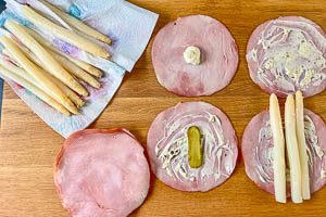 Schinken mit Remoulade, Gurken und Spargel belegen und aufrollen.