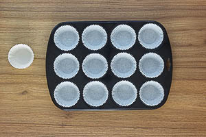 Muffinblech mit Papierförmchen bestücken