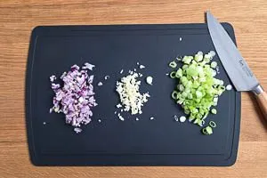 Rote Zwiebeln, Knoblauchzehe und Fr&uuml;hlingszwiebeln vorbereiten.