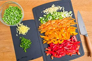 Knoblauch, Ingwer, Peperoni und Gemüse kleinschneiden