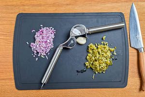 Rote Zwiebeln und Essiggurken schneiden. Knoblauch sch&auml;len.