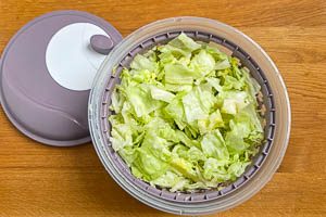 Eisbergsalat waschen, schneiden, schleudern