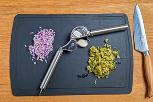 Rote Zwiebeln und Knoblauch sch&auml;len. Rote Zwiebel und Gew&uuml;rzgurken fein w&uuml;rfeln.