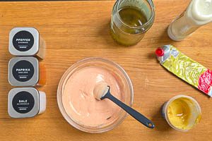 Basis aus Mayo, Gurkenwasser, Senf, Tomatenmark, Paprikapulver, Salt und schwarzem Pfeffer anr&uuml;hren.