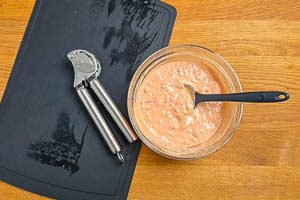 Knoblauchzehe in Sauce pressen, Zwiebel und Gurken unterr&uuml;hren.