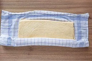 Biskuitboden mit K&uuml;chentuch aufrollen.