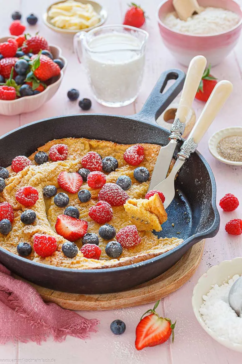 Anschneiden des Pfannkuchens "Dutch Baby" mit Beeren