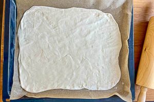 Ofen vorheizen, Teig ausrollen und auf ein Backblech geben