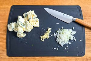 Zwiebeln, Knoblauch und Gorgonzola klein schneiden