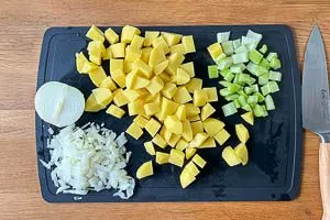 Kartoffeln, Sellerie und Zwiebel klein schneiden.