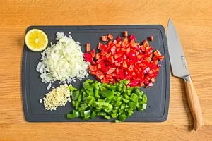 Knoblauch, Zwiebeln und Paprika w&uuml;rfeln