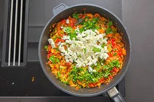 Menemen mit Petersilie und Fetaw&uuml;rfeln bestreuen