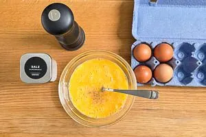 Eier, Salz und Pfeffer in einer Sch&uuml;ssel verr&uuml;hren