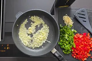 Zwiebelw&uuml;rfel in Oliven&ouml;l glasig and&uuml;nsten