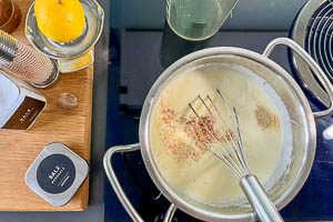 Die Bechamelsauce mit Fl&uuml;ssigkeit aufgie&szlig;en und w&uuml;rzen.