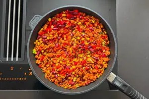 Fr&uuml;hlingszwiebeln, Knoblauch, Paprika, Mais und Kidneybohnen zum Sojahack geben und mit braten