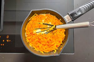 Käse und Chili in die Soße geben