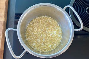 Brühe, Senf, Essig, Zucker und Zwiebeln aufkochen und heiß halten